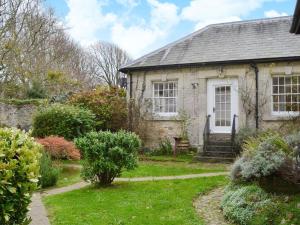 uma antiga casa de pedra com um jardim em Westgate Cottage em Saint Lawrence