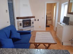 a living room with a blue couch and a fireplace at Villa Imperia in Imperia