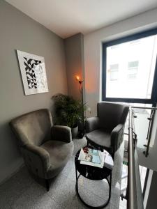 mala me Hotel في هانوفر: غرفة معيشة مع كرسيين وطاولة