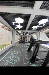 Apartment in kileleshwa في نيروبي: صالة ألعاب رياضية مع آلة ركض في غرفة مع نوافذ