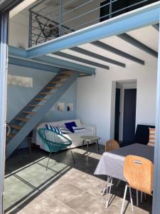 a living room with a blue staircase and a couch at Maison contemporaine Oléron in Saint-Denis-dʼOléron