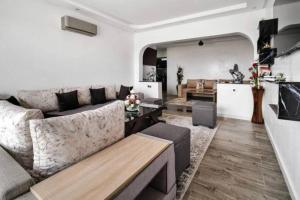 een woonkamer met een bank en een tafel bij Magnifique appartement en plein centre ville in Marrakesh