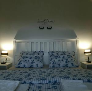 a bedroom with a bed with a headboard and two lamps at Elegant Inn Gospić in Gospić