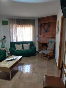 sala de estar con sofá verde y mesa en Casa joselito, en Casas del Cerro