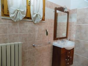 ein Bad mit einem Waschbecken und einem Spiegel in der Unterkunft B&B Le Cave in Avetrana
