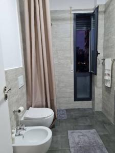a bathroom with a toilet and a sink and a shower at Apartment Aulona Park in Vlorë