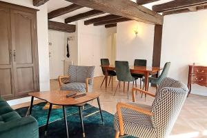 a living room with a wooden table and chairs at LE PLUMEREAU Appartement historique Vieux Tours avec parking in Tours