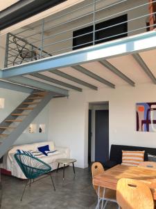 a loft apartment with a staircase and a living room at Maison contemporaine Oléron in Saint-Denis-dʼOléron