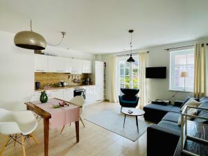 a living room with a table and a blue couch at Ferienwohnung am Apfelgarten in Ahrenshoop