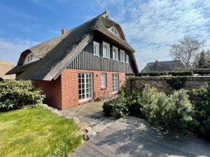 una casa antigua con techo de paja en Ferienwohnung am Apfelgarten, en Ahrenshoop