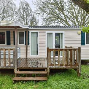 una casa con una gran terraza de madera en el césped en Mobil home Onesse et Laharie RML Newcamp "le bois des Landes", en Onesse-et-Laharie