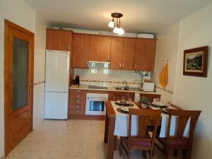 - une cuisine avec des placards en bois et un réfrigérateur blanc dans l'établissement Apartamento Martina, à Jarandilla de la Vera