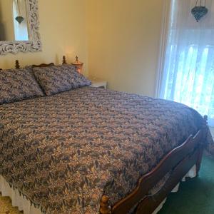 a bedroom with a bed and a mirror and a window at Innisfree Bed & Breakfast in South Bend