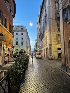 een persoon die door een straat met gebouwen loopt bij Anna’s Crazy Place in Rome