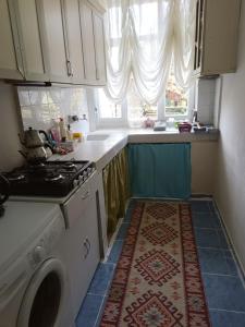 a kitchen with a stove and a washing machine at daily rental apartment 5 minutes to the airport in Pazar