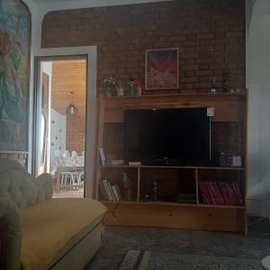 uma sala de estar com televisão num centro de entretenimento em madeira em Casa para Aluguel de Temporada - Carrancas MG em Carrancas