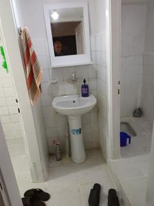 a small bathroom with a sink and a mirror at daily rental apartment 5 minutes to the airport in Pazar