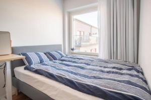 łóżko w sypialni z oknem w obiekcie Private room in Hammarby Sjöstad, common space shared! w Sztokholmie
