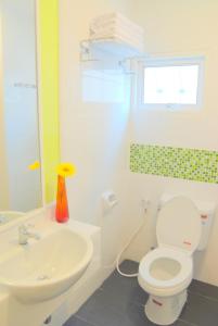 Łazienka z białą toaletą i umywalką w obiekcie The Inn Saladaeng w mieście Bangkok