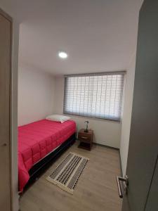 um quarto com uma cama vermelha e uma janela em Hermoso departamento nuevo amoblado em Arica