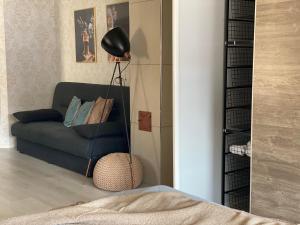 a living room with a blue couch and a black lamp at Hundbergan apartment-free parking-15 min from Tromsø in Trondalen