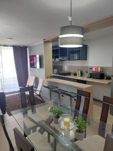 uma sala de jantar e cozinha com uma mesa de vidro e cadeiras em Hermoso departamento nuevo amoblado em Arica