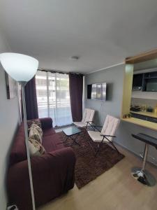 sala de estar con sofá y 2 sillas en Hermoso departamento nuevo amoblado en Arica