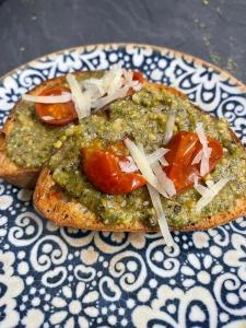 two slices of bread with pesto and tomatoes on a plate at La Casa Di Chiaretta in Falerna