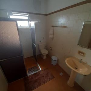 a bathroom with a shower and a toilet and a sink at Casa para Aluguel de Temporada - Carrancas MG in Carrancas