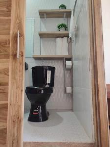 ein Bad mit einem schwarzen WC in einem Zimmer in der Unterkunft ROOM AYAMPE - La Casa de Eros in Ayampe