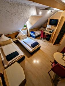 Cette chambre comprend deux lits, une table et des chaises. dans l'établissement Hotel am Rathaus, à Cassel