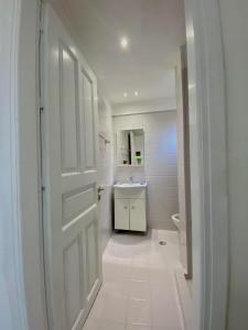 a white bathroom with a sink and a door at Villa Saradari in Hersonissos