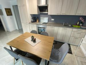 a kitchen with a wooden table with chairs and a sink at Olive in Uhldingen-Mühlhofen
