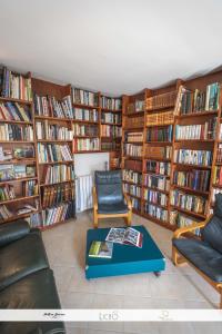 a library with a lot of bookshelves at Le Nid des Anges, votre studio à la campagne. in Saint-Laurent-du-Plan