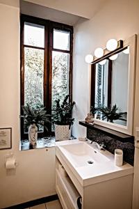 a bathroom with a sink and a mirror and a window at BELLE REINE - 3 APPARTEMENTS EN COEUR DE CENTRE-VILLE in Aix-les-Bains