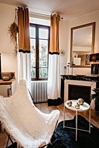 salon z krzesłem i kominkiem w obiekcie BELLE REINE - 3 APPARTEMENTS EN COEUR DE CENTRE-VILLE w Aix-les-Bains