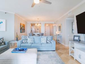 sala de estar con sofá azul y TV en Beach Colony West 2c, en Perdido Key