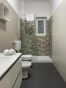 uma casa de banho com um WC e uma parede de pedra em Casa Bolina - Mini appartamento em Taranto
