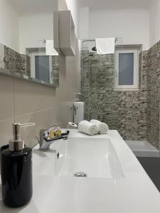 y baño blanco con lavabo y bañera. en Casa Bolina - Mini appartamento, en Taranto