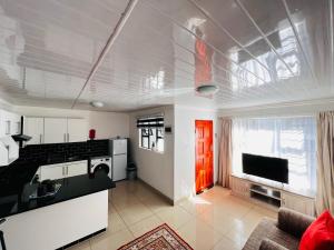a kitchen and living room with a red door at Safi 1 bedroom Suite 9 in East London