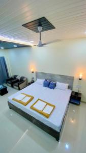 een slaapkamer met een groot bed en een bank bij Ashoka Lawns and Resort in Alibaug