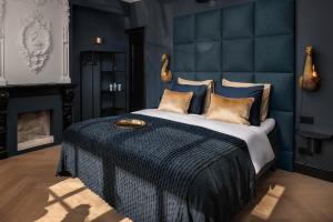 een slaapkamer met een groot bed en een open haard bij Boutique Hotel The Roosevelt in Middelburg