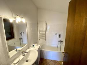 y baño blanco con bañera, lavamanos y bañera. en Casetta in Campagna Fiorano, en Poggio Catino