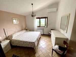 1 dormitorio con 1 cama, 1 silla y 1 ventana en Casetta in Campagna Fiorano, en Poggio Catino