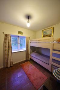 a bedroom with two bunk beds and a window at Vakantiewoning Zandhof in Oostduinkerke