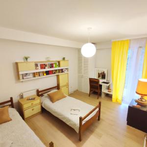 a bedroom with a bed and a desk with a chair at Rooms & Apartment GH Pasha in Tuzla