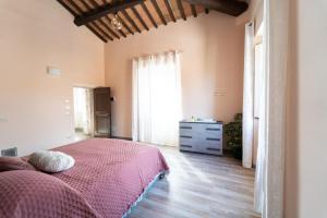 a bedroom with a bed and a dresser and a window at Casale Il Terranova in Cortona