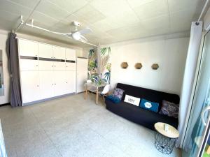 een woonkamer met een bank en een tafel bij Grand studio cosy à 300m de la mer avec parking in Canet-en-Roussillon
