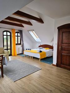 1 dormitorio con 1 cama con sábanas amarillas y suelo de madera en Apartamenty z Klimatem, en Ustka
