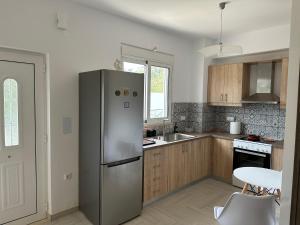 a kitchen with a stainless steel refrigerator and wooden cabinets at River Home in Agia Galini